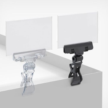 Klips do etykiet cenowych z dużą klamrą, przezroczysty i czarny, na ekspozycji z etykietami, widok z kąta